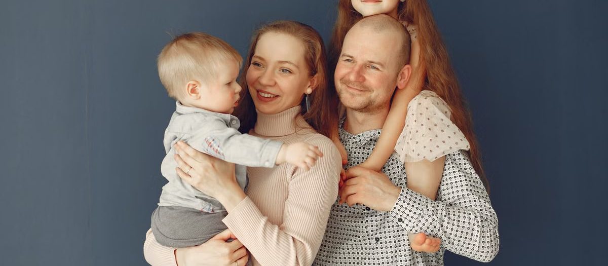 A joyful family portrait showcasing parents and their two children, expressing love and togetherness.