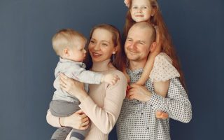 A joyful family portrait showcasing parents and their two children, expressing love and togetherness.